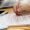 77942564 - hand holding red pen over proofreading text in office
